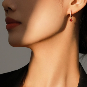 Elegant S925 silver hoop earrings with red zircon pendant shown on model