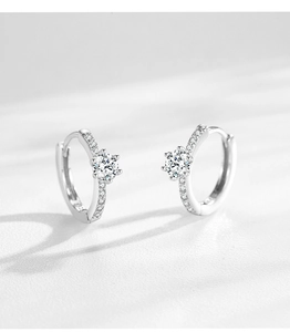 Détail de boucles d'oreilles huggie en argent 925 avec zircons sertis à six griffes