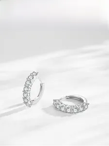 Détail de créoles en argent avec zircons micro-pave et ombre lumineuse élégante