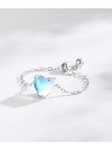 Macro shot of an adjustable silver chain ring with a heart-shaped blue moonstone