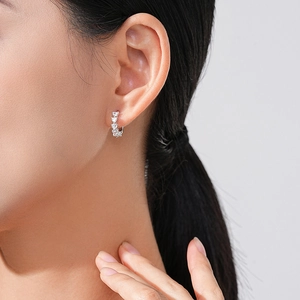 Elegant S925 sterling silver heart-shaped cubic zirconia hoop earrings worn by a model