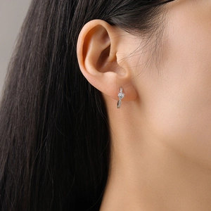 Boucles d'oreilles créoles classiques en argent 925 avec zircons portées par un mannequin
