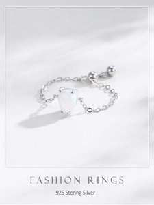 Macro detail of S925 sterling silver chain ring with teardrop opal gemstone inlay