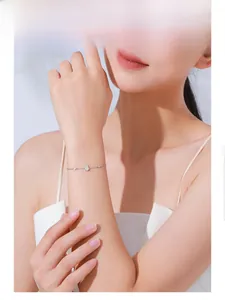 Detail eines S925 Silberarmbands mit Wassertropfen-Diamanten am Handgelenk