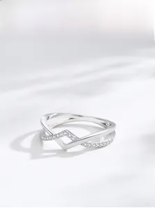 Macro shot of silver geometric cross ring with sparkling cubic zirconia on light background