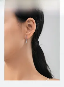 Close-up of S925 sterling silver hoop earring with paved zircon letter A pendant on ear