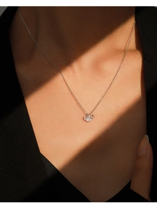 Close-up of S925 silver necklace with three sparkling stones worn on a female model