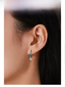 Model wearing vintage S925 sterling silver earrings with square turquoise stones