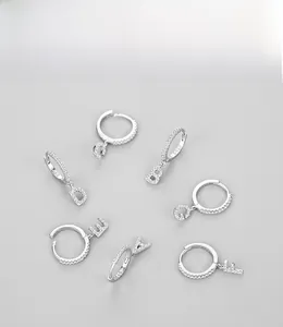 Detail view of S925 sterling silver hoop earrings with zircon pavé letter pendants A to G