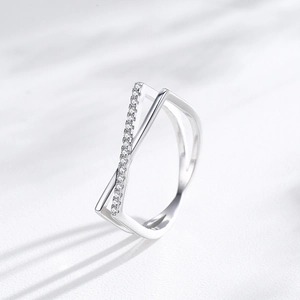 Modern S925 sterling silver criss cross ring with micro-pave diamonds on marble background