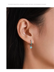Close-up of S925 sterling silver drop earring with geometric turquoise stone on ear