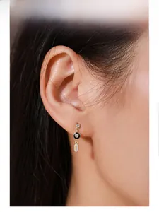 Close-up of S925 silver 14K gold-plated earring with black enamel and pavé crystals