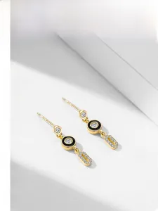 Macro view of gold-plated S925 silver earrings with black enamel and micro-pave diamonds
