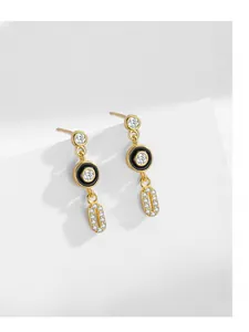 Detail of S925 silver earrings with black enamel, pave diamonds, and 14K gold plating