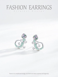 Macro detail of silver lizard stud earring with colorful zircons and mint enamel
