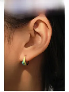 Detail of S925 silver rainbow enamel U-shaped hoop earring on model with blue and yellow colors