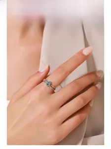 Model wearing S925 silver cross ring with turquoise heart and purple zircon accents