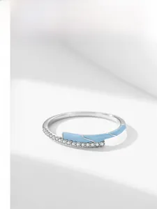 Detail of silver S925 ring featuring light blue enamel and micro-set sparkling zircons