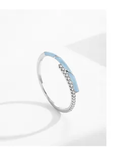 Macro detail of S925 silver ring featuring light blue enamel and micro-pave crystals