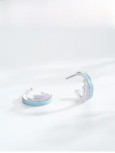 Close-up of S925 silver J-hoop earrings with rainbow enamel and pavé-set zircons