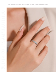 Detail of a thin silver ring with light blue enamel inlay and micro-pave crystals on finger