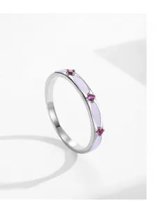 Detailed macro of S925 silver ring featuring purple enamel and micro-set red gemstones