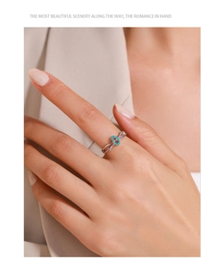 Detailed view of silver infinity ring with blue turquoise and purple zircon on finger