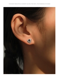 Vue rapprochée de la boucle d'oreille cœur en émail violet ornée de cristaux sur le lobe