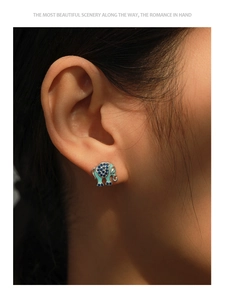 Close-up of S925 silver elephant stud earrings with blue enamel and zircon worn by model