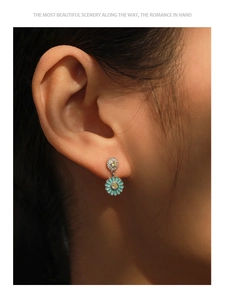 Close-up of S925 silver sunflower earrings with blue enamel and micro-pave crystals