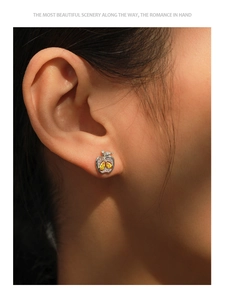 Gros plan de boucles d'oreilles pomme en argent avec pierres jaunes et cristaux