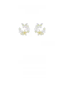 Détails macro des boucles d'oreilles papillon et fleurs en argent S925 avec zircons jaunes