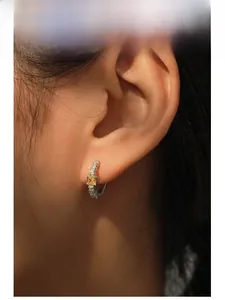 Détail d'une boucle d'oreille en argent S925 avec zircon jaune et pavage de diamants