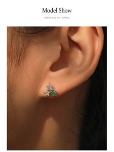 Gros plan sur les boucles d'oreilles fleur en argent S925 avec zircons colorés portées
