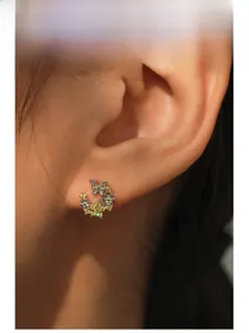 Gros plan de boucles d'oreilles papillon et fleur en argent S925 avec cristal jaune