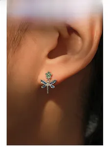 Macro detail of S925 silver dragonfly stud earrings with rainbow zircon stones