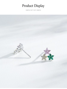 Vue macro des boucles d'oreilles en argent S925 avec fleurs en zircone de couleurs pastel