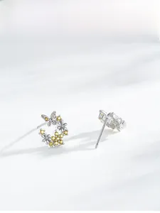 Détail macro de boucles d'oreilles papillon fleur en argent S925 et zircone jaune