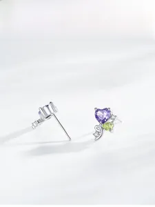 Macro shot of S925 silver heart stud with purple zirconia and green gem detail