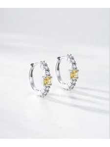 Détail macro de créoles en argent S925 avec zircon carré jaune et cristaux brillants