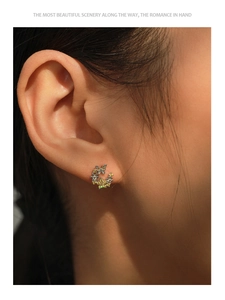 Gros plan de boucles d'oreilles en argent S925 avec fleurs, papillons et cristaux jaunes
