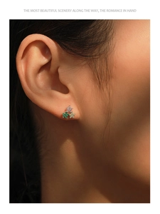 Gros plan de boucles d'oreilles en argent S925 avec zircons colorés portées par un mannequin