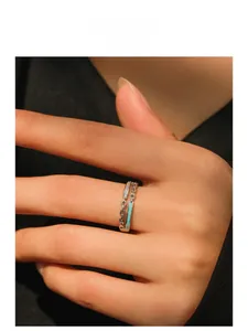 Detail of S925 silver chain ring with green enamel and zircons worn on finger