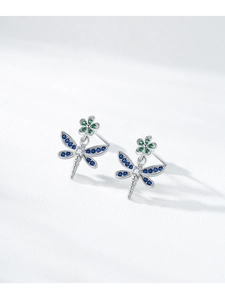 Macro view of S925 silver dragonfly earrings with blue zircon wings and green floral studs