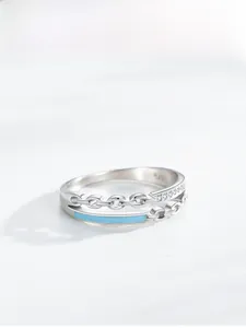 Macro detail of S925 sterling silver chain ring with blue enamel and pavé crystals