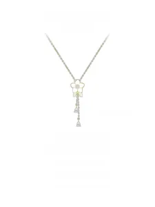 Détail d'un collier orchidée doré avec fleur émaillée blanche et gemmes en gouttes