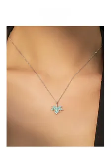 Close-up of blue enamel maple leaf pendant with pavé zircons on a silver chain necklace