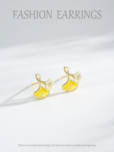 Close-up of S925 sterling silver ginkgo leaf stud earrings with yellow enamel and 14K gold plating