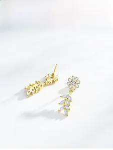 Macro detail of S925 silver daisy earrings with enamel petals and shiny zircon leaves