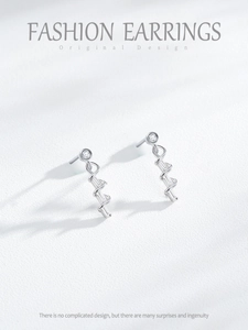 Macro detail of silver spiral drop earrings with inlaid baguette cut zircons